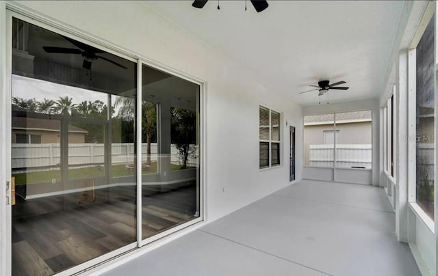 unfurnished sunroom with ceiling fan