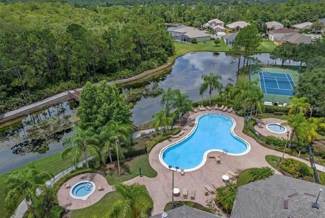 view of pool featuring tennis court, a community hot tub, and a water view