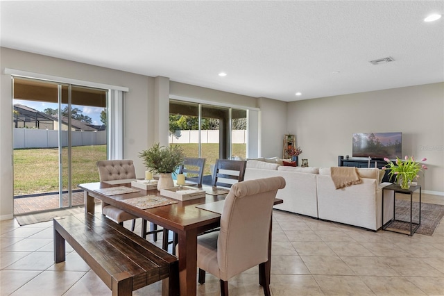 tiled dining space with a textured ceiling