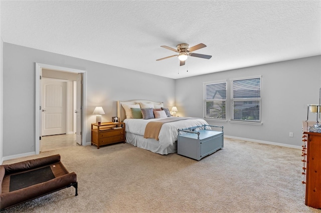 bedroom featuring ceiling fan, light carpet, and a textured ceiling