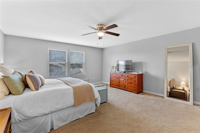 carpeted bedroom featuring ceiling fan and a textured ceiling