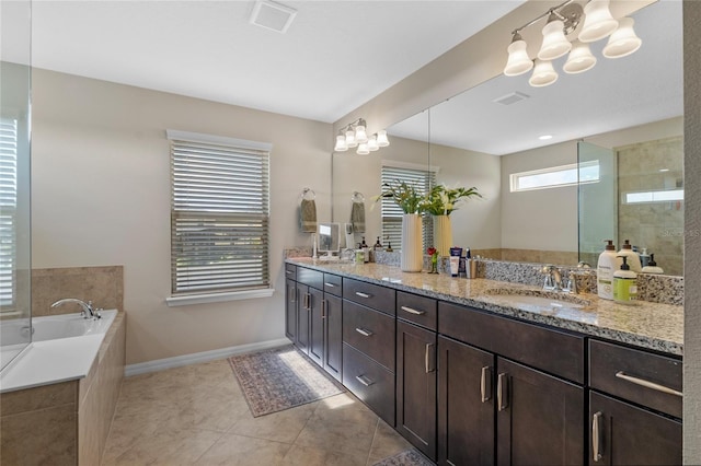 bathroom featuring a relaxing tiled tub, tile patterned floors, and vanity