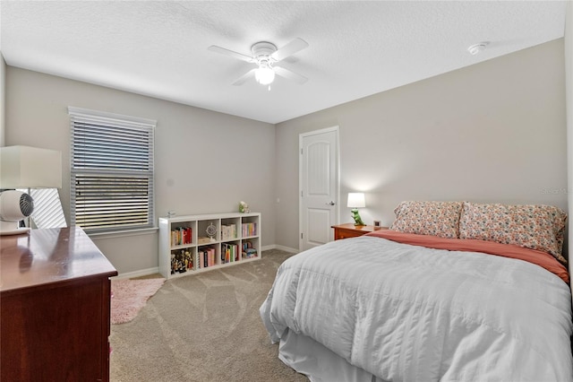 bedroom featuring ceiling fan, light carpet, and a textured ceiling