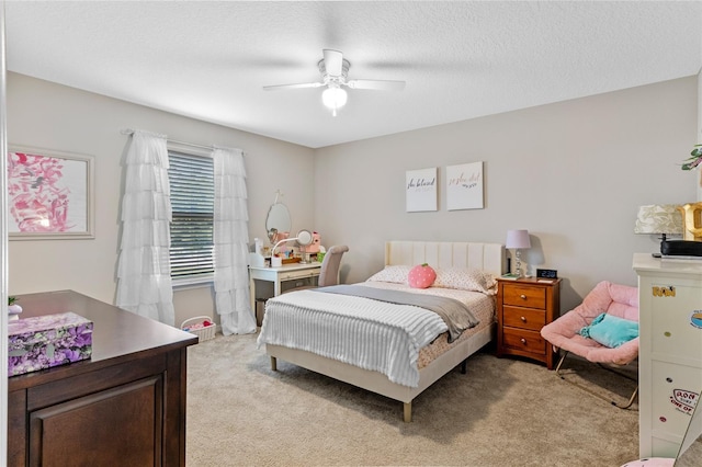 bedroom with ceiling fan, light carpet, and a textured ceiling