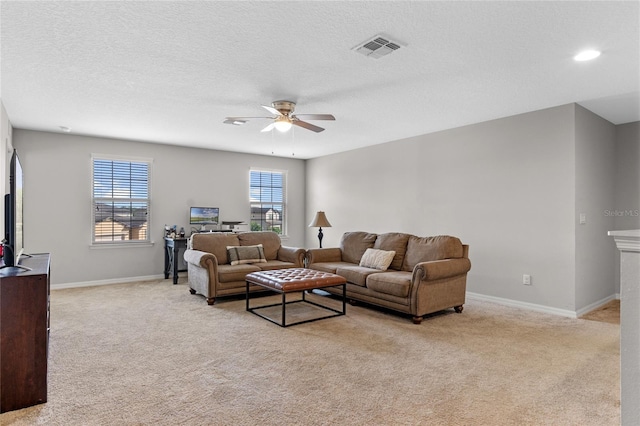 carpeted living room with ceiling fan and a textured ceiling