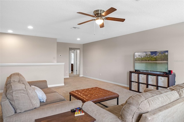 living room featuring light carpet, a textured ceiling, and ceiling fan