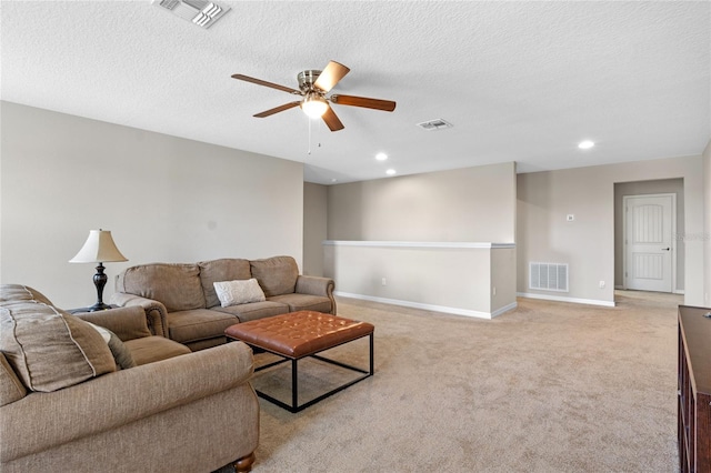 living room featuring light carpet, a textured ceiling, and ceiling fan