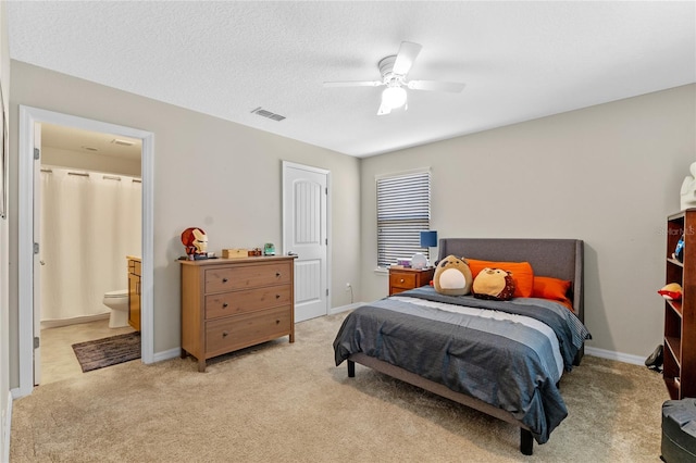 carpeted bedroom with connected bathroom, a textured ceiling, and ceiling fan