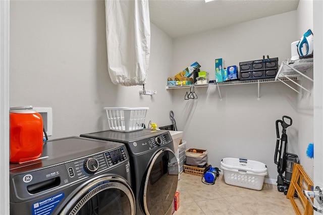 clothes washing area with separate washer and dryer and light tile patterned floors