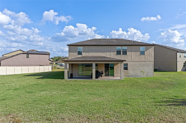 rear view of house with a patio area and a lawn