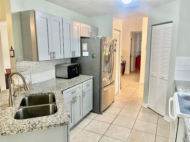 kitchen featuring light tile patterned flooring, white electric range oven, sink, gray cabinetry, and light stone counters