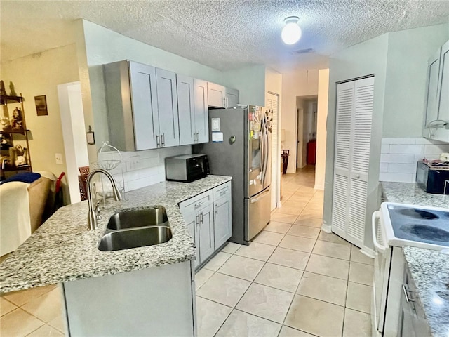 kitchen featuring sink, gray cabinetry, light stone counters, stainless steel fridge with ice dispenser, and white range with electric cooktop