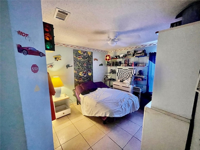 tiled bedroom with ceiling fan and a textured ceiling