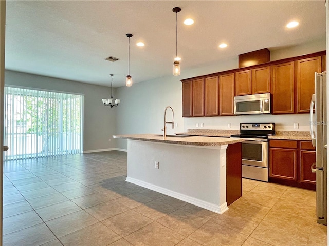 kitchen with sink, an inviting chandelier, decorative light fixtures, appliances with stainless steel finishes, and a kitchen island with sink