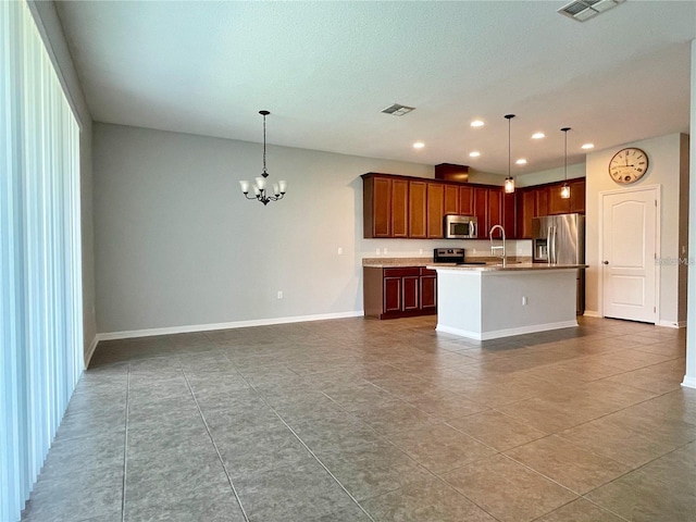 kitchen featuring pendant lighting, sink, appliances with stainless steel finishes, a notable chandelier, and a center island with sink