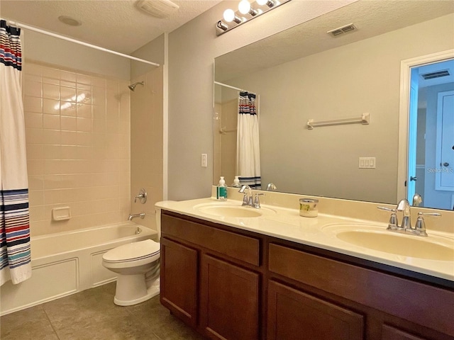 full bathroom featuring vanity, shower / bath combination with curtain, a textured ceiling, tile patterned floors, and toilet