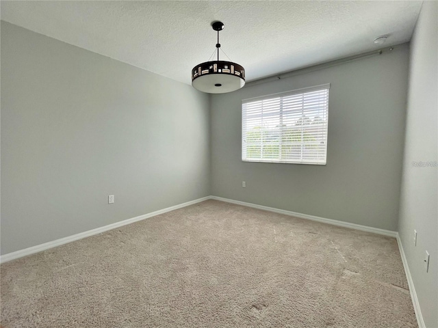 carpeted empty room featuring a textured ceiling