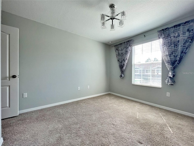 spare room with ceiling fan, carpet flooring, and a textured ceiling