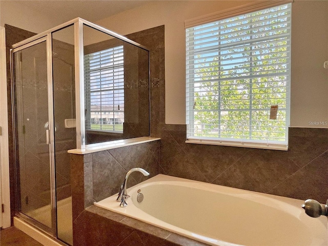 bathroom featuring a healthy amount of sunlight and independent shower and bath