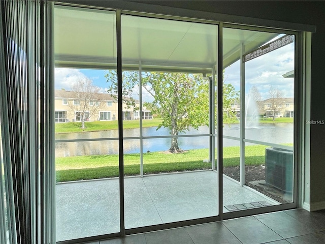 doorway featuring tile patterned flooring, plenty of natural light, and a water view