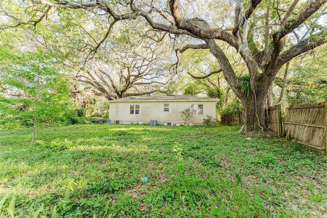 view of yard with central AC and fence