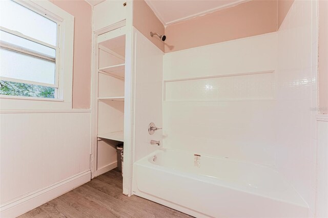 full bathroom with shower / bathtub combination, wood finished floors, and wainscoting