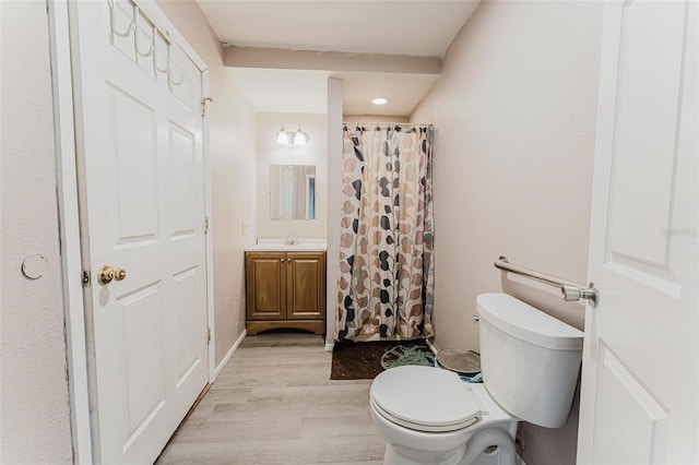 full bathroom with a shower with shower curtain, toilet, wood finished floors, and vanity