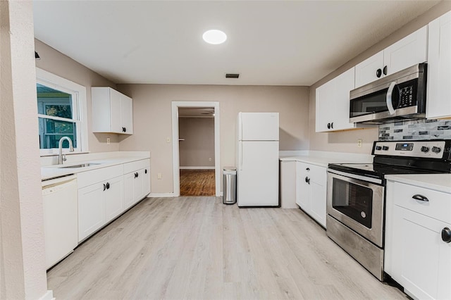 kitchen with visible vents, light wood-style flooring, a sink, light countertops, and appliances with stainless steel finishes