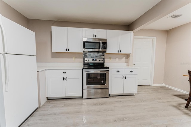 kitchen featuring light wood-type flooring, appliances with stainless steel finishes, white cabinetry, and light countertops