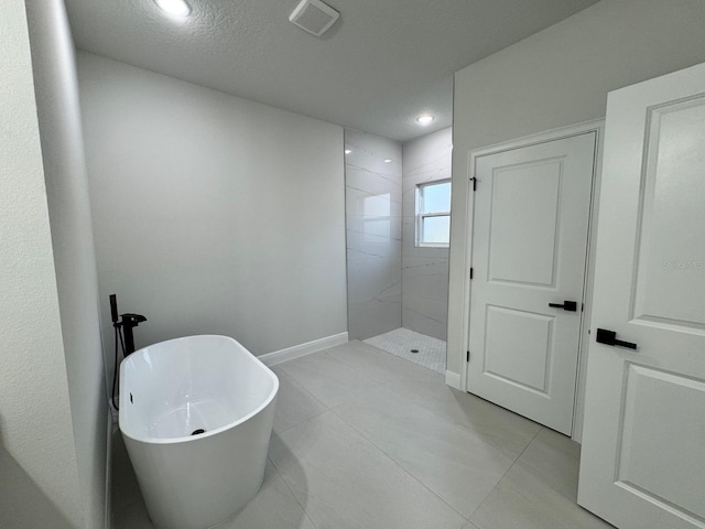 150 Marion Oaks Trl, Ocala, FL 34473 - bathroom with baseboards, a soaking tub, a textured ceiling, walk in shower, and visible vents