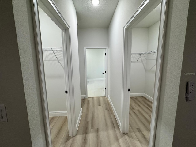 150 Marion Oaks Trl, Ocala, FL 34473 - hallway featuring light wood-style flooring, a textured ceiling, and baseboards