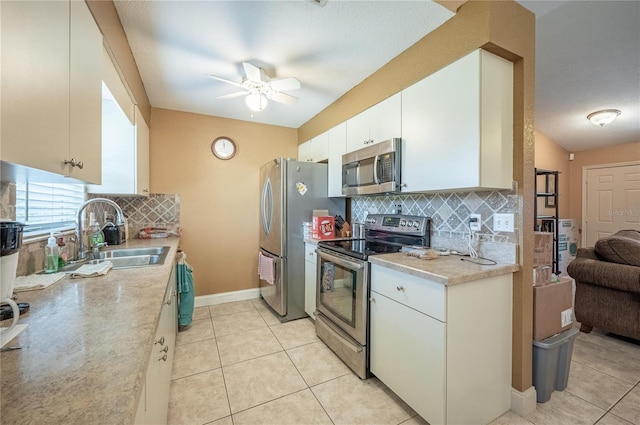 kitchen featuring white cabinetry, appliances with stainless steel finishes, sink, and light tile patterned floors