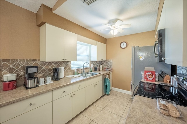 kitchen with light tile patterned flooring, sink, appliances with stainless steel finishes, ceiling fan, and backsplash