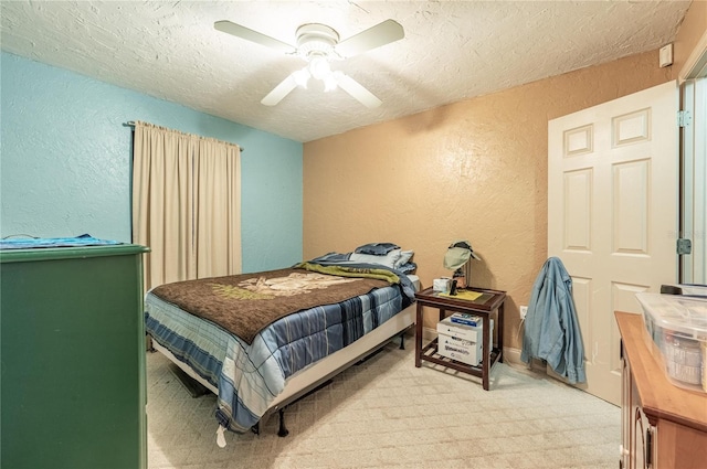 bedroom with ceiling fan, carpet flooring, and a textured ceiling