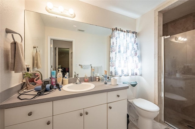 bathroom with vanity, an enclosed shower, and toilet