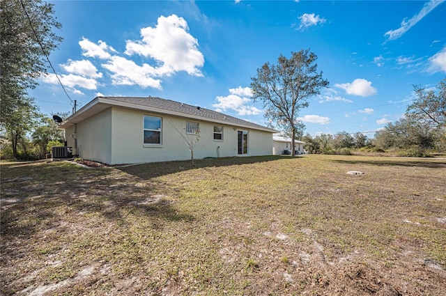 rear view of house featuring a yard and central AC unit