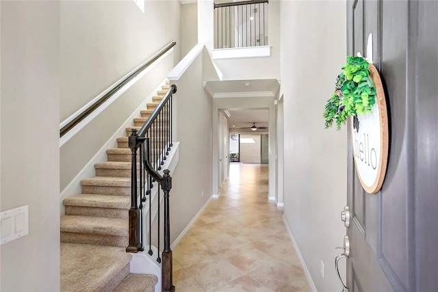 entryway featuring crown molding and a towering ceiling