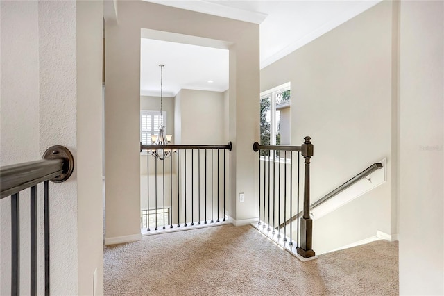 stairs featuring crown molding, carpet flooring, and a chandelier