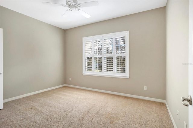 carpeted spare room featuring ceiling fan