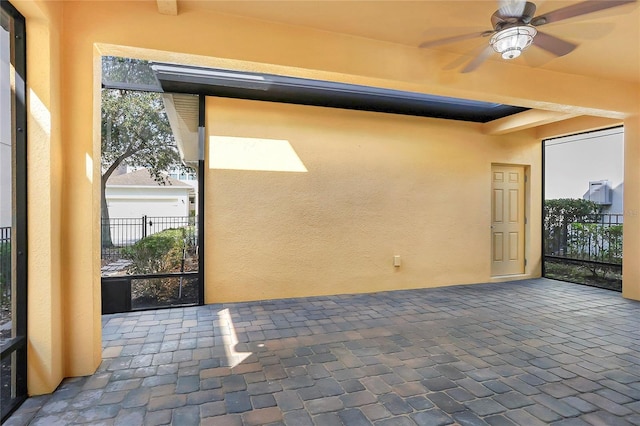 unfurnished sunroom featuring ceiling fan and a wealth of natural light