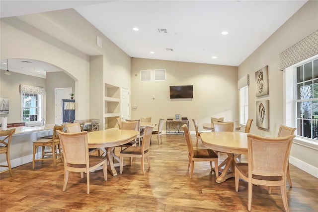 dining room featuring lofted ceiling and light hardwood / wood-style floors