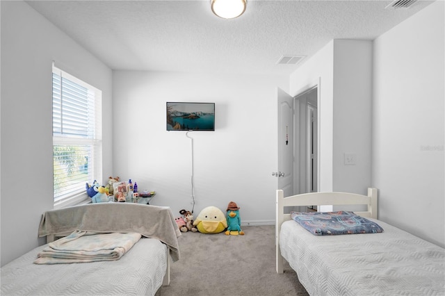 bedroom with a textured ceiling and carpet