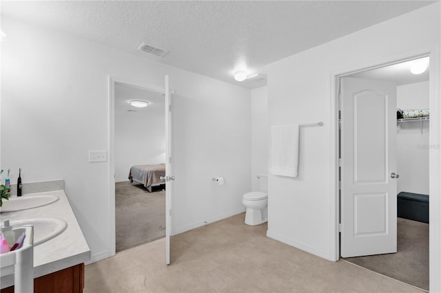 bathroom featuring vanity, toilet, and a textured ceiling