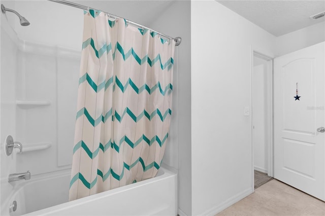 bathroom featuring tile patterned flooring, a textured ceiling, and shower / bath combo