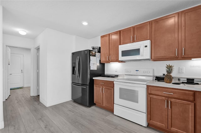361 Preserve Pointe Blvd, Davenport, FL 33837 - kitchen with white appliances, light countertops, brown cabinets, light wood-style flooring, and recessed lighting