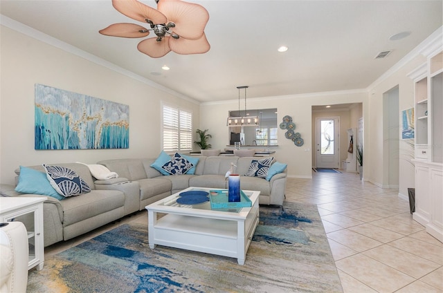 tiled living room with ornamental molding and ceiling fan