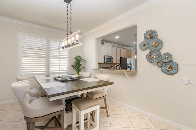 dining room featuring ornamental molding, sink, and light tile patterned floors