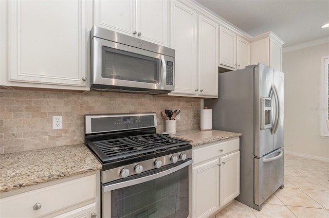 kitchen featuring light tile patterned floors, white cabinetry, stainless steel appliances, light stone counters, and decorative backsplash