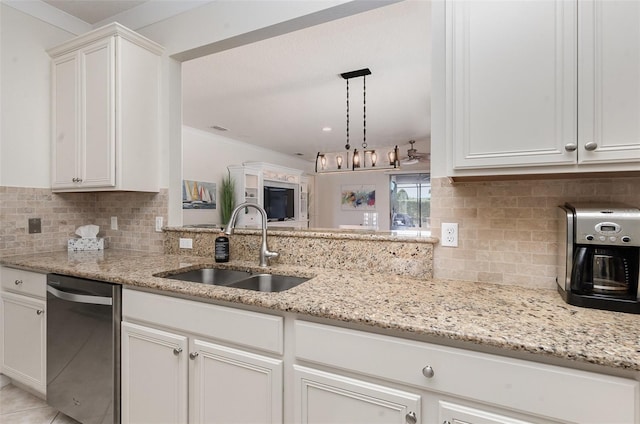 kitchen featuring sink, light stone counters, hanging light fixtures, stainless steel dishwasher, and white cabinets