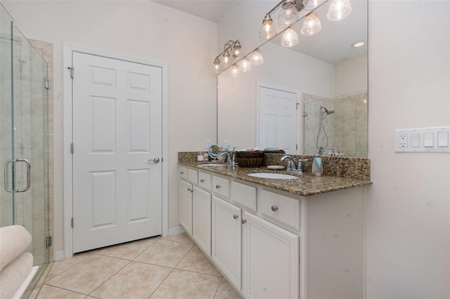 bathroom featuring a shower with door, vanity, and tile patterned floors